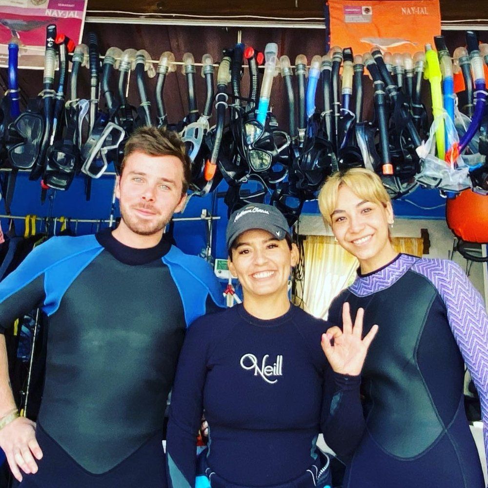 Equipo y clientes con trajes de neopreno en la tienda de Mismaloya Adventures